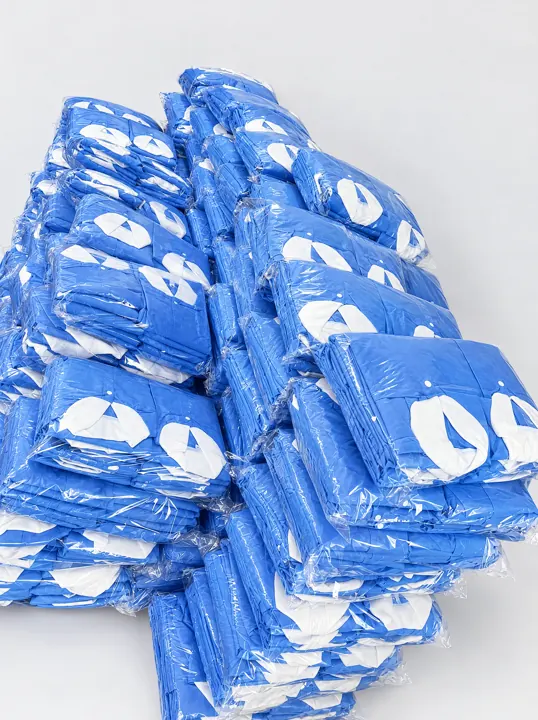 Stack of individually bagged blue gowns | Einzeln verpackte Einwegkittel | Camici monouso confezionati singolarmente