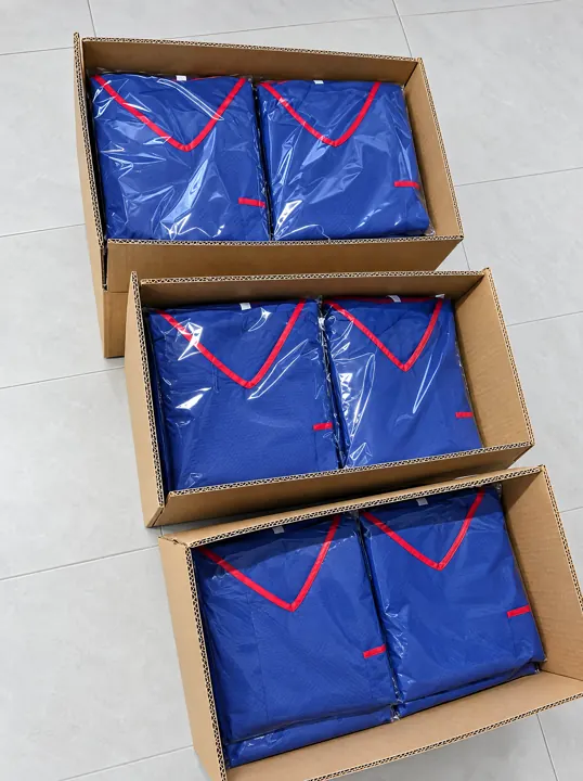 Bagged navy scrub sets packed in cartons | Verpackte Einweg-OP-Sets | Completi monouso in scatola