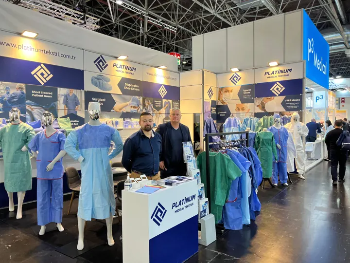 Meeting visitors at our booth – scrub and gown samples on mannequins | Kundengespräch am Messestand | Incontro con i clienti allo stand
