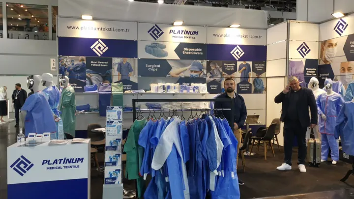 Gown and scrub samples on the garment rack at our booth | Messestand – Kleiderstange mit Mustern | Stand in fiera – espositore con campioni