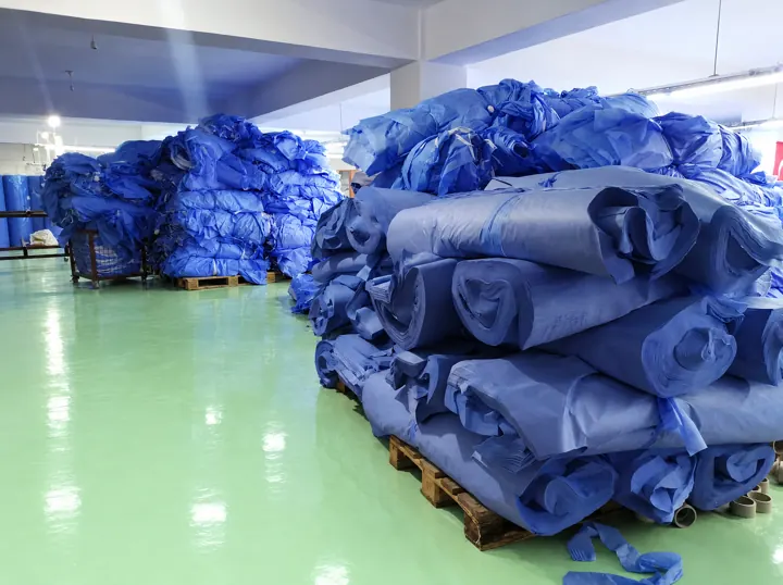 Warehouse – our SMS fabric and product rolls stacked on pallets | Lager – unsere SMS-Vliesrollen | Magazzino – i nostri rotoli di tessuto SMS